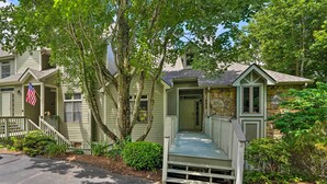 A two-story house with a front porch, a stone facade, and a flag. - Family-friendly Burnsville Condo! Gated Community (Burnsville)