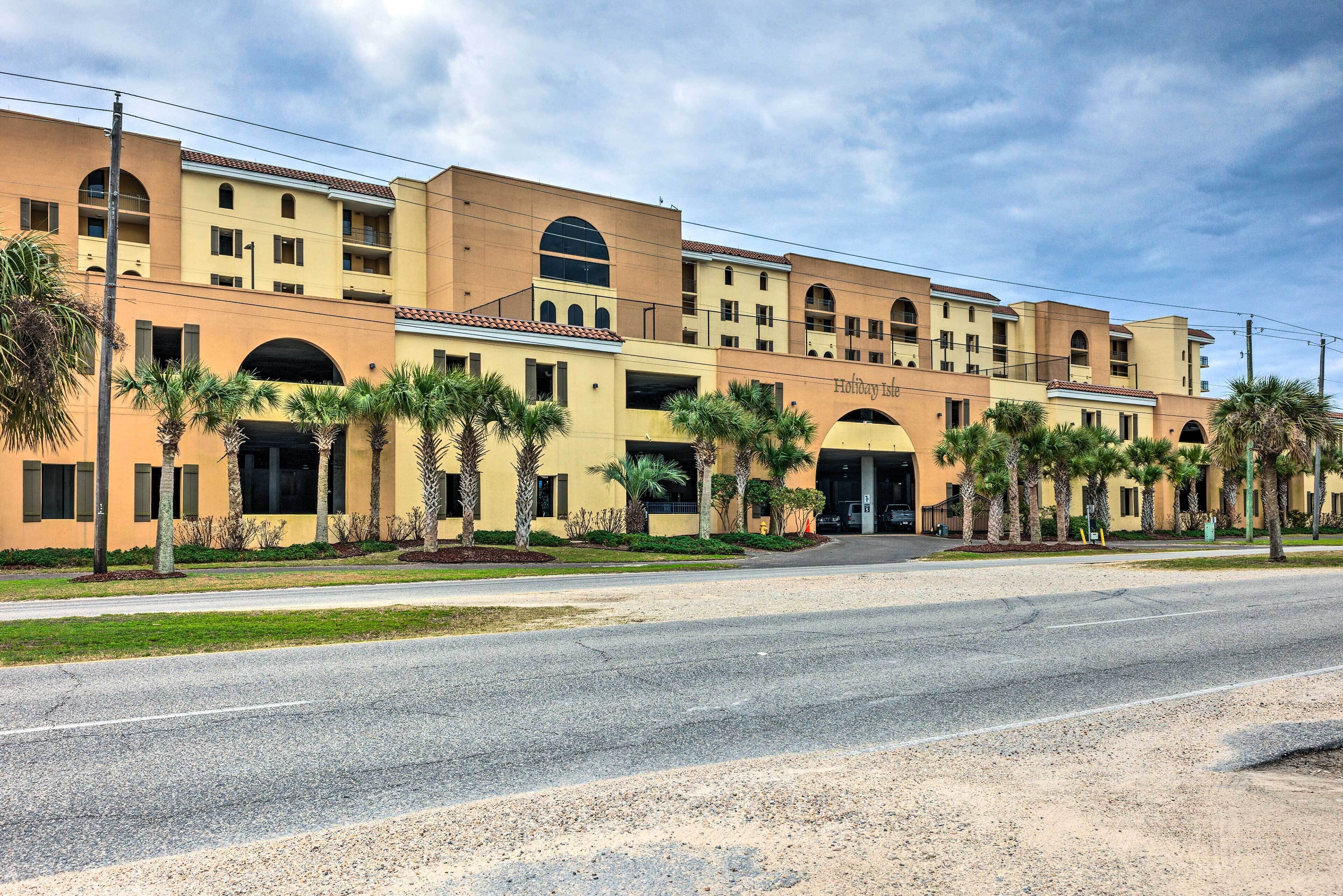 A multi-story hotel with a yellow facade, arched windows, and a central entrance.