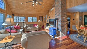 A spacious living room with wooden floors, a fireplace, and a television.
