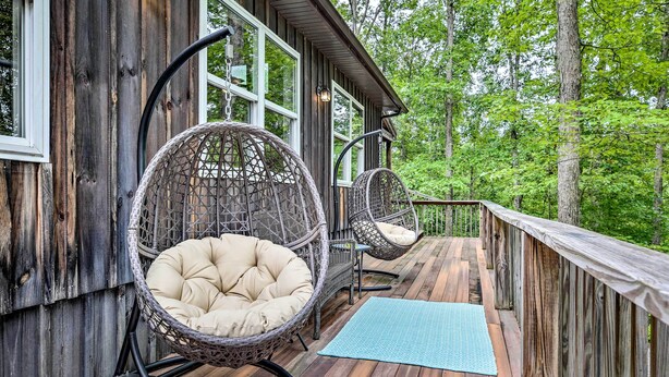 A wooden deck with wicker chairs and a blue mat. - Hike & Zip-line: Red River Gorge Cabin w/ Hot Tub! (Zoe)