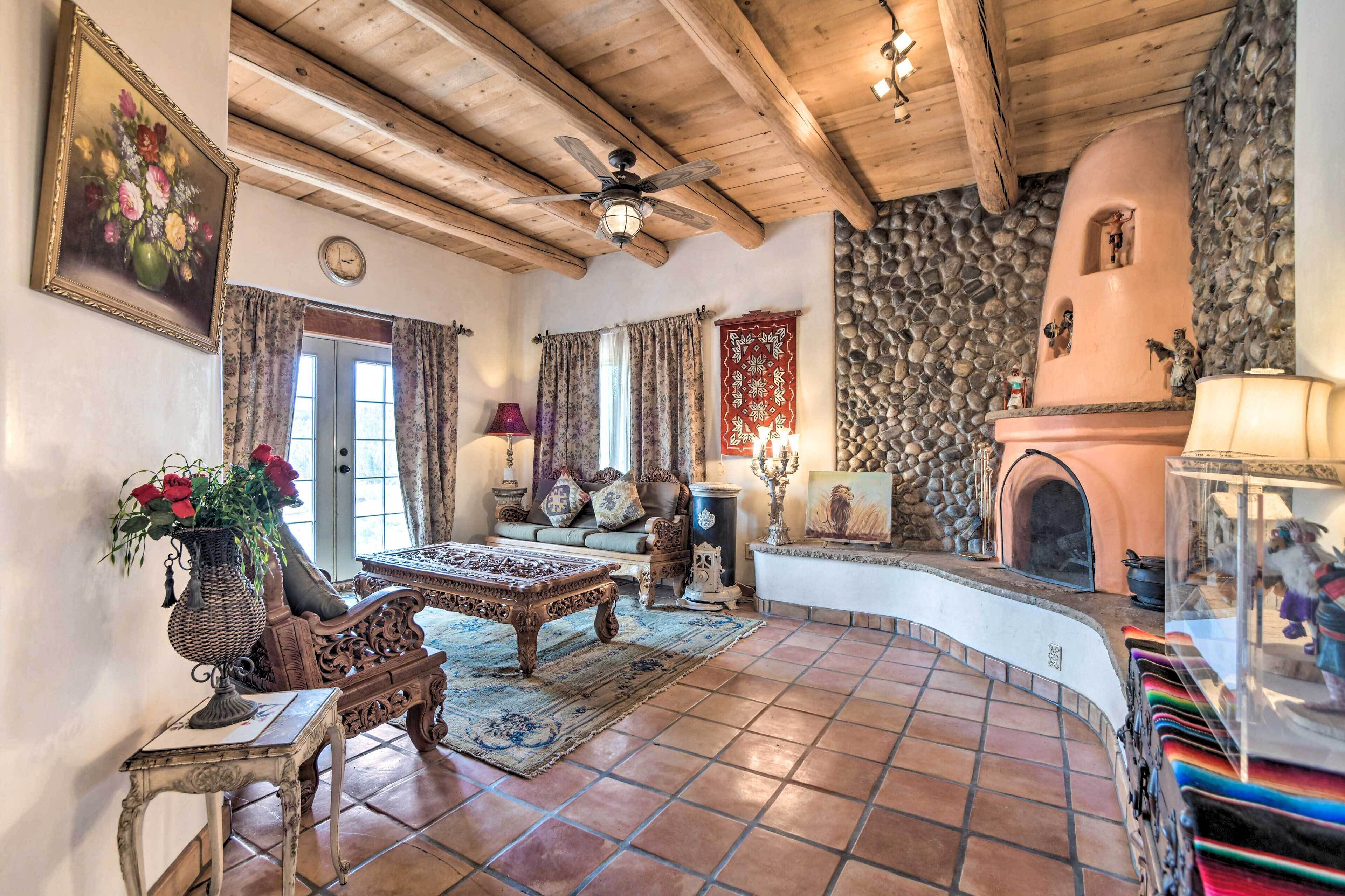 A rustic interior with a stone fireplace, wooden ceiling beams, and a traditional sofa.