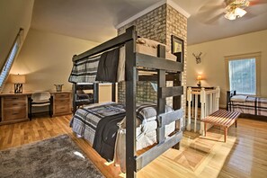 A bunk bed with a stone facade, a desk with a lamp, and a window with blinds. - Spacious Mcgaheysville Family Retreat w/ Game Room (McGaheysville)