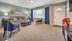 A living room with a sofa, two armchairs, a coffee table, and a TV stand. - Homey Duplex - 10 Mi to Downtown Grand Rapids! (Jenison)