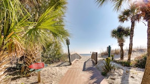 A wooden boardwalk leading to a beach with palm trees and a clear sky. - Walk to Beach: Hilton Head Resort Condo w/ Pools! (Hilton Head Island)
