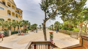 A beachfront property with a wooden deck, palm trees, and a sandy beach. - Walk to Beach: Hilton Head Resort Condo w/ Pools! (Hilton Head Island)