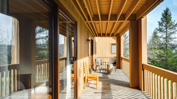 A wooden deck with a wooden railing, a table, and chairs. - Golf & Adventure! Condo 2 Mi to Dtwn Ellicottville (Great Valley)