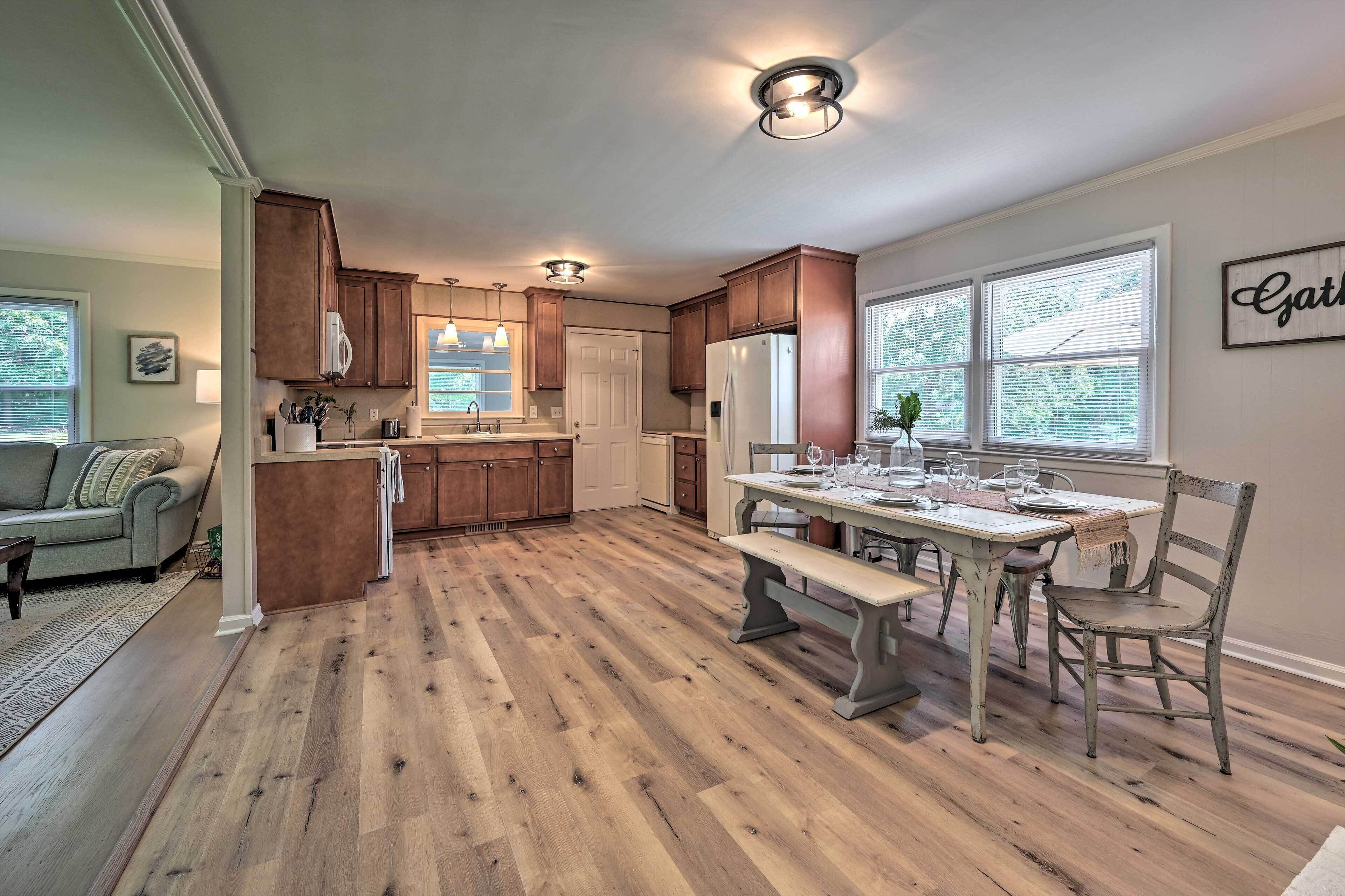 Una cocina con armarios de madera, una mesa de comedor con bancos y un refrigerador.