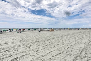 A sandy beach with umbrellas and beach chairs, indicating a beachside location. - Pelicans Watch Beachfront Condo With Ocean Views! (Myrtle Beach)