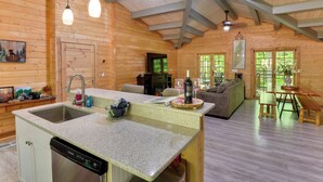Een vakantiehuisje van hout met een keuken, eethoek en woonkamer.