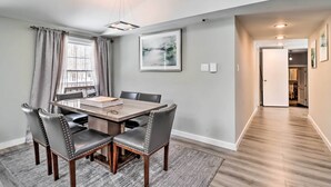 A dining area with a rectangular table, six chairs, a window with curtains, a ceiling light, and a hallway leading to another room. - Hot Tub & Fire Pit: Modern Pocono Mountain Home (Pocono Lake)