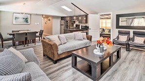 A modern living room with a sofa, coffee table, and dining area. - Hot Tub & Fire Pit: Modern Pocono Mountain Home (Pocono Lake)