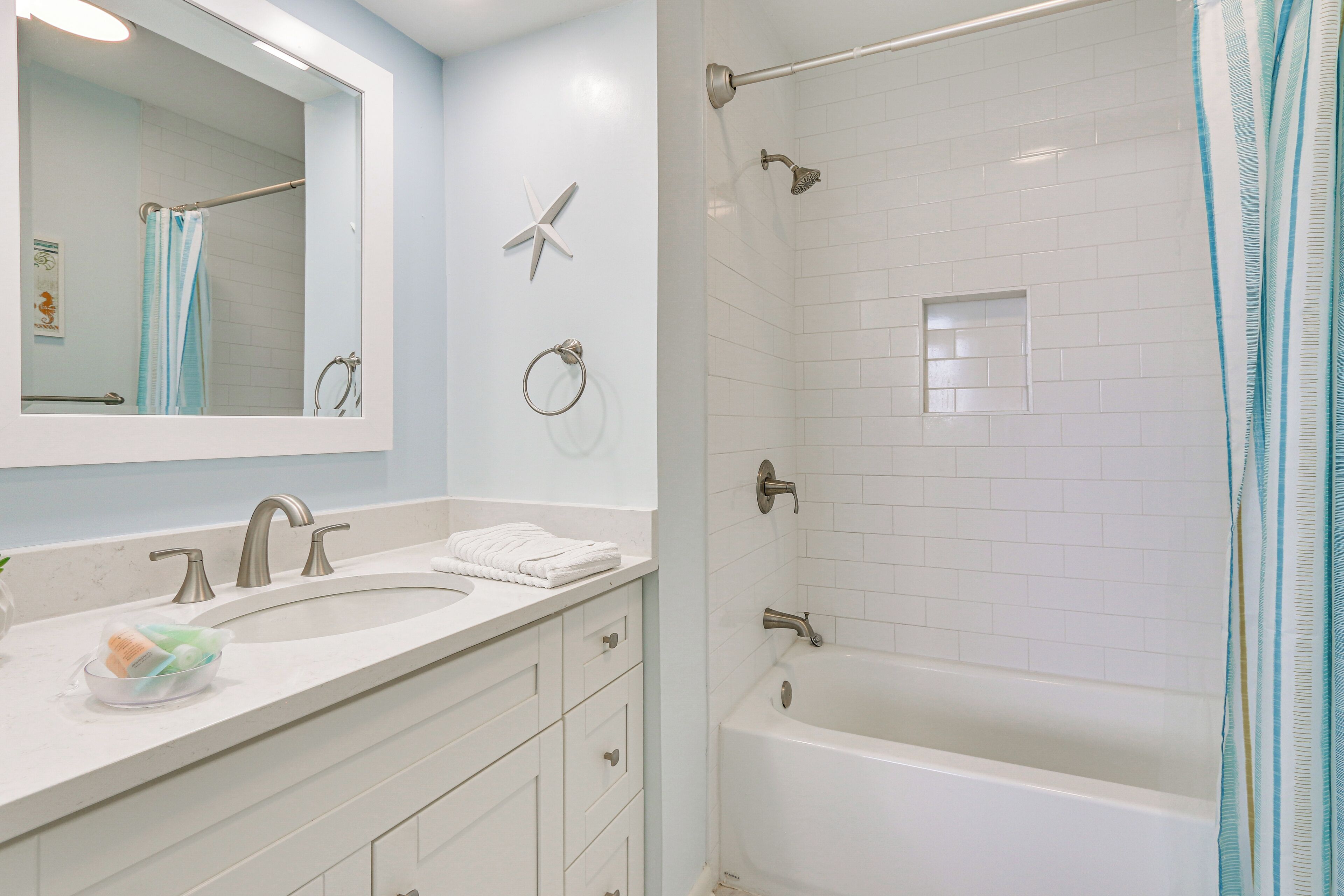 A modern bathroom with a double sink, a large mirror, a shower with a glass door, and a towel rack.