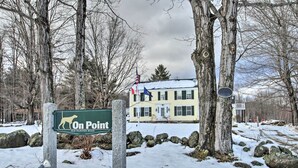 Segnaletica per 'On Point' su Old Warner Road, immersa in un paesaggio innevato e alberi.