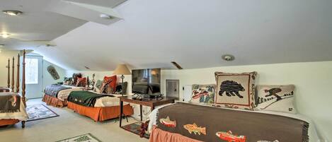 A cozy room with two beds, a desk, and a television.