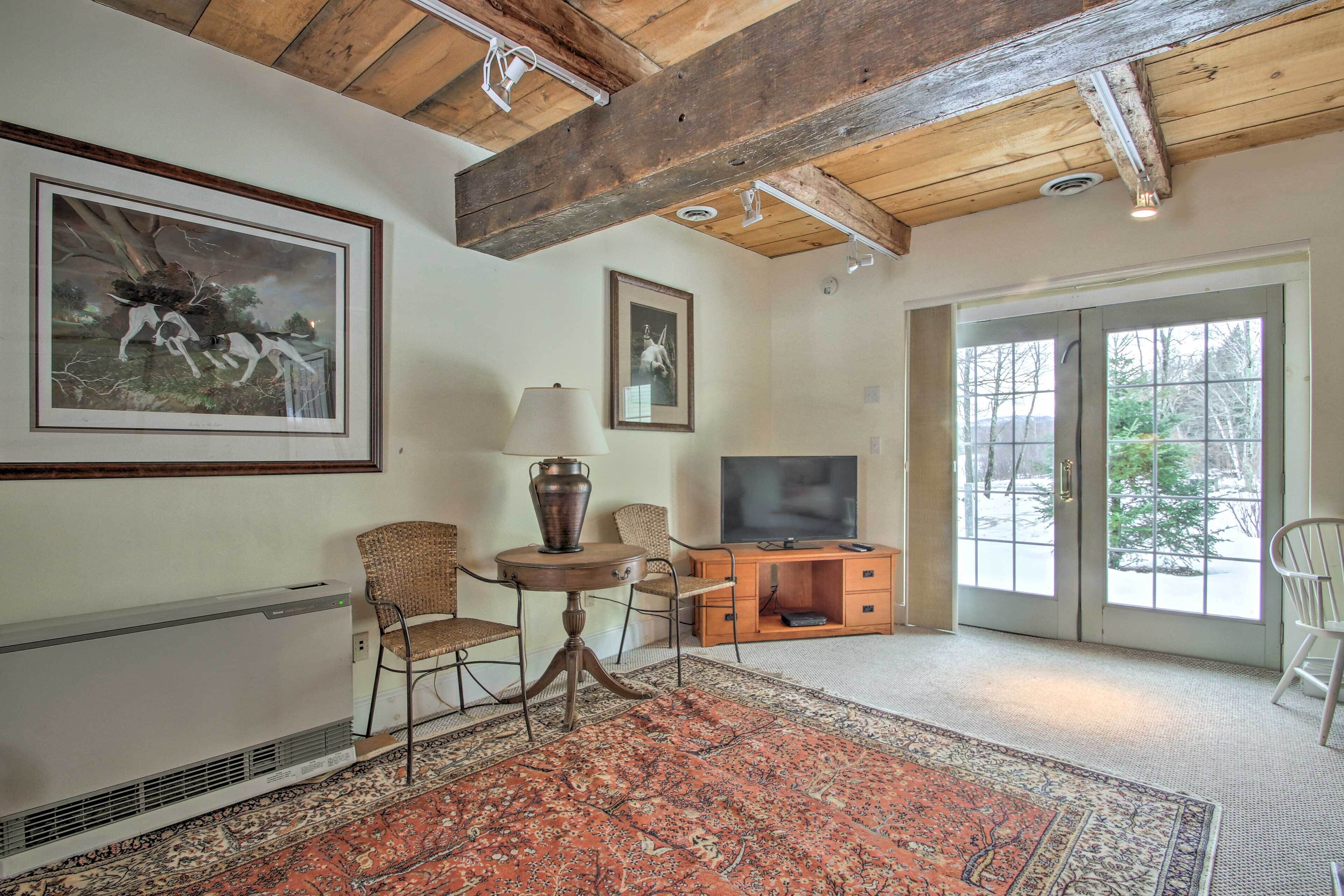 A living room with a fireplace, a television, and a large window.
