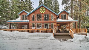 A log cabin with a stone foundation, large windows, and a wooden deck. - Garden Valley Cabin w/ Loft & Large Deck! (Garden Valley)