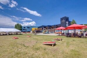 An outdoor area with picnic tables, umbrellas, and a playground.