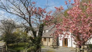 Un bâtiment en pierre avec une porte en bois, une table de pique-nique et un panneau indiquant « BOLTHOLE’S CIDERWALK ».