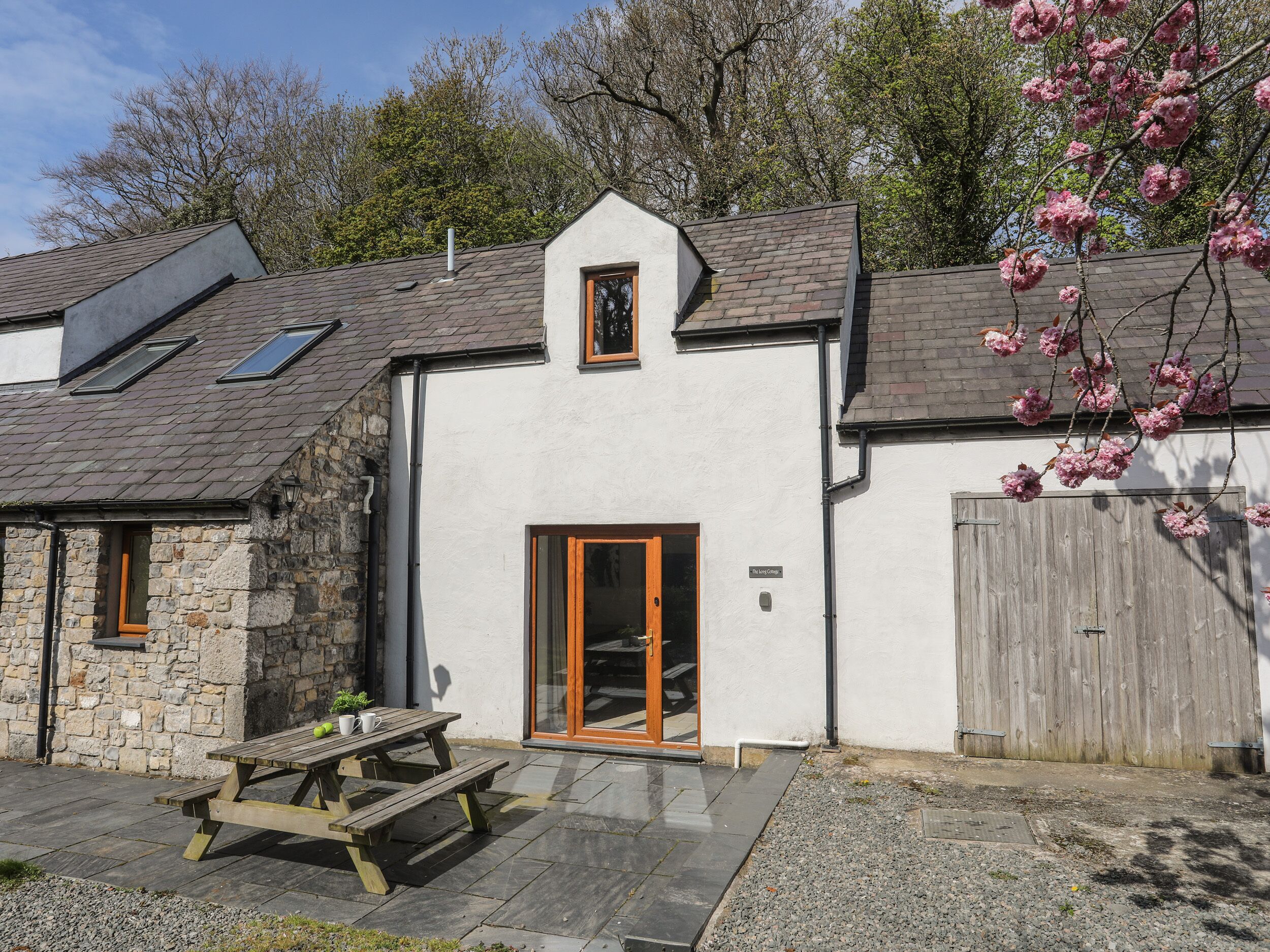 A two-story house with a stone facade, a wooden door, and a small window.