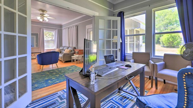 A spacious living area with a wooden desk, computer, and seating. - Spacious Lanett Haven w/ Sunroom + Large Deck (Lanett)