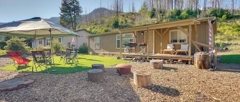 A cabin with a deck, outdoor seating, and a covered area.