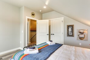 A bedroom with a bed, a door leading to a hallway, and a framed picture on the wall. - Spacious, Rustic Spearfish Home: Walk to Downtown! (Spearfish)