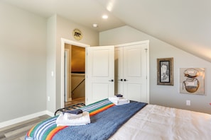 A bedroom with a bed, a door leading to a hallway, and a framed picture on the wall. - Spacious, Rustic Spearfish Home: Walk to Downtown! (Spearfish)