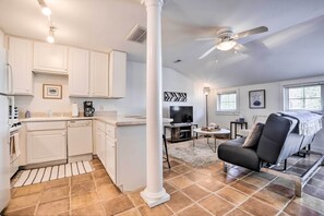 A spacious living area with a fireplace, a black leather sofa, and a large window. - Modern Chapel Hill Condo: Convenient to Hot Spots! (Chapel Hill)