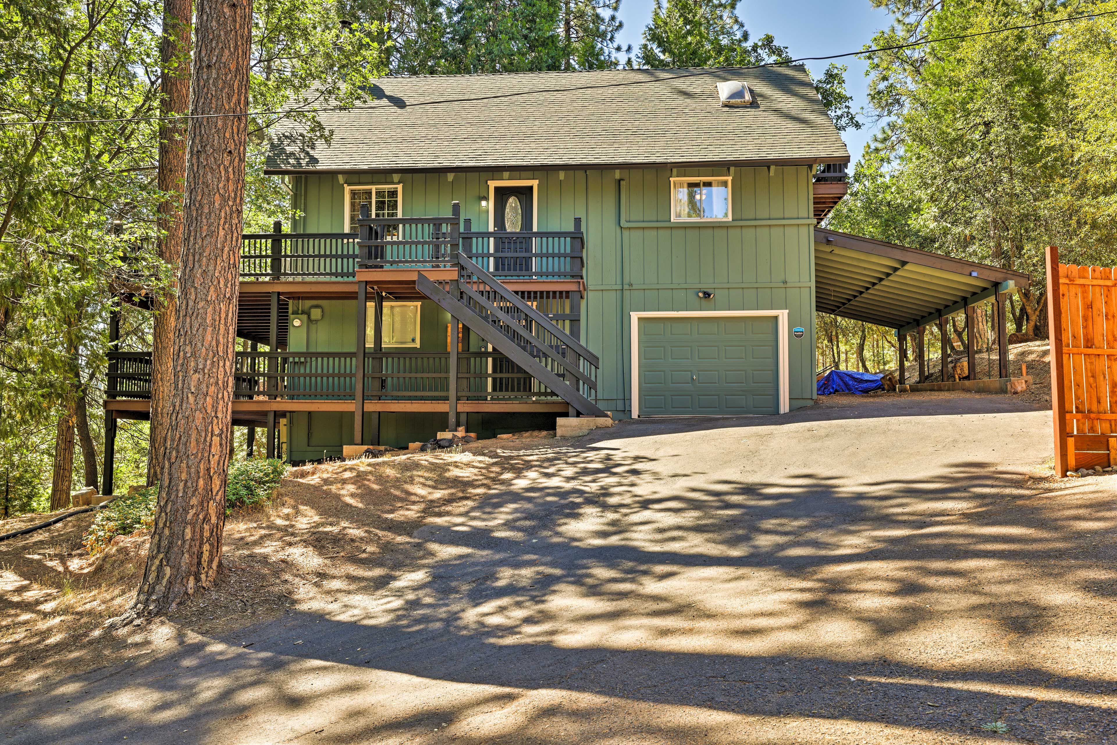 A two-story house with a covered porch, a garage, and a staircase leading to a balcony.