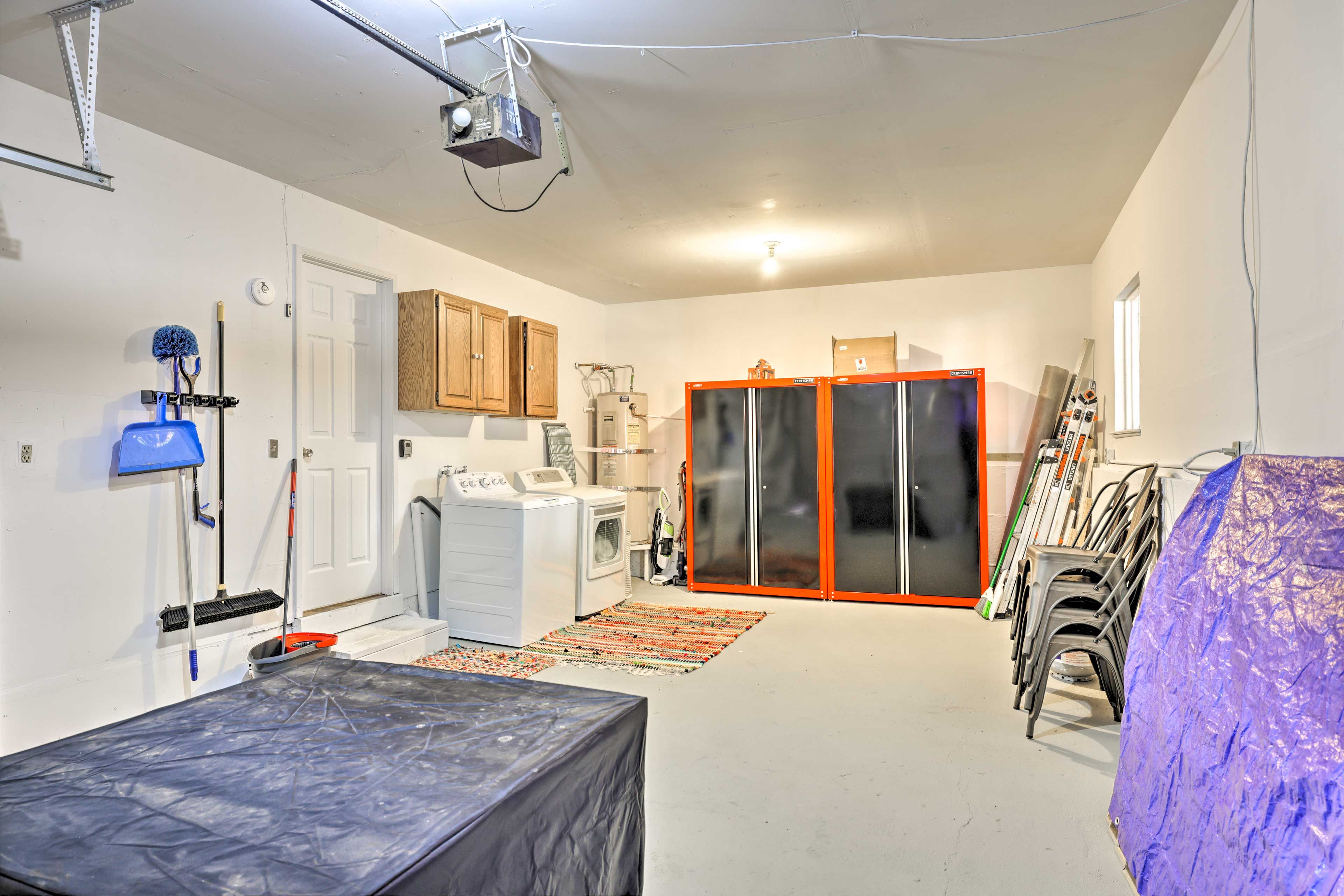 Una habitación amplia con una cama grande, lavadora, refrigerador y armario con puerta corredera de cristal.