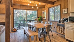 A wooden interior with a dining table, benches, and a kitchen area. - Near Trails: Cabin w/ 2-level Deck in Twain Harte (Twain Harte)