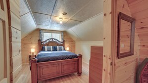 A bedroom with a wooden bed, a nightstand, a dresser, and a window with a view of the outside. - 6 Mi to Shingleton: Manistique Home w/ Yard! (Manistique)