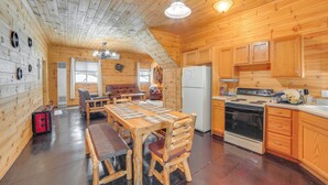 A log cabin interior with a dining area, kitchen, and a cozy living room. - 6 Mi to Shingleton: Manistique Home w/ Yard! (Manistique)