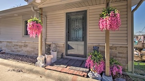 A house with a front porch, a door with a decorative glass panel, and two hanging flower baskets. - Private Dock, Waterfront Views! Sunrise Beach Home (Sunrise Beach)