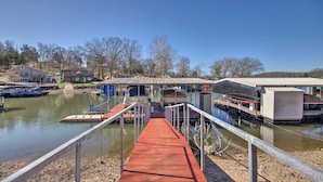 A dock leading to a marina with boats and a covered structure. - Private Dock, Waterfront Views! Sunrise Beach Home (Sunrise Beach)