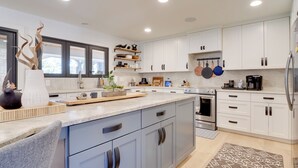 A modern kitchen with white cabinets, a marble countertop, and stainless steel appliances. - Pool, Patio & Privacy! Home Near Georgetown Square (Georgetown)