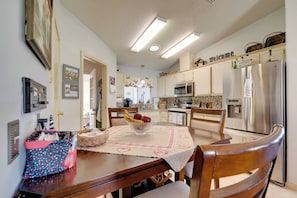 A kitchen with a dining table, chairs, and a fruit bowl. - Lady Lake House w/ Lanai & Community Pool! (Lady Lake)