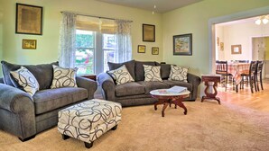 Ein Wohnzimmer mit zwei Sofas, einem Couchtisch und einem Essbereich mit Tisch und Stühlen.