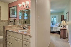 Une salle de bain avec un grand miroir, un lavabo et un meuble-lavabo doté de tiroirs.