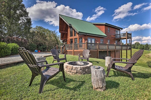A wooden cabin with a stone fire pit and outdoor seating.