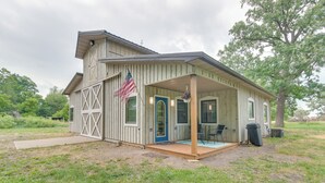 Eine Holzjagdhaus mit Veranda, einer blauen Tür und einer amerikanischen Flagge.