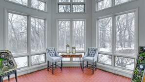 A room with large windows, two chairs, a small table, and a potted plant. - Spacious & Secluded Madison Home Near Dtwn! (Madison)