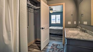 Un baño moderno con un espejo grande, un lavabo y una zona de ducha.