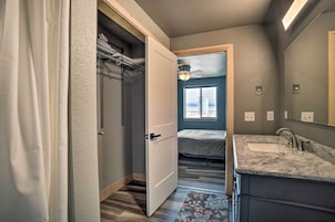 Un baño moderno con un espejo grande, un lavabo y una zona de ducha.