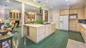 A spacious kitchen with a central island, wooden cabinets, and a microwave. - Lush Elkin Home w/ Porch Views & Pool Table (Elkin)