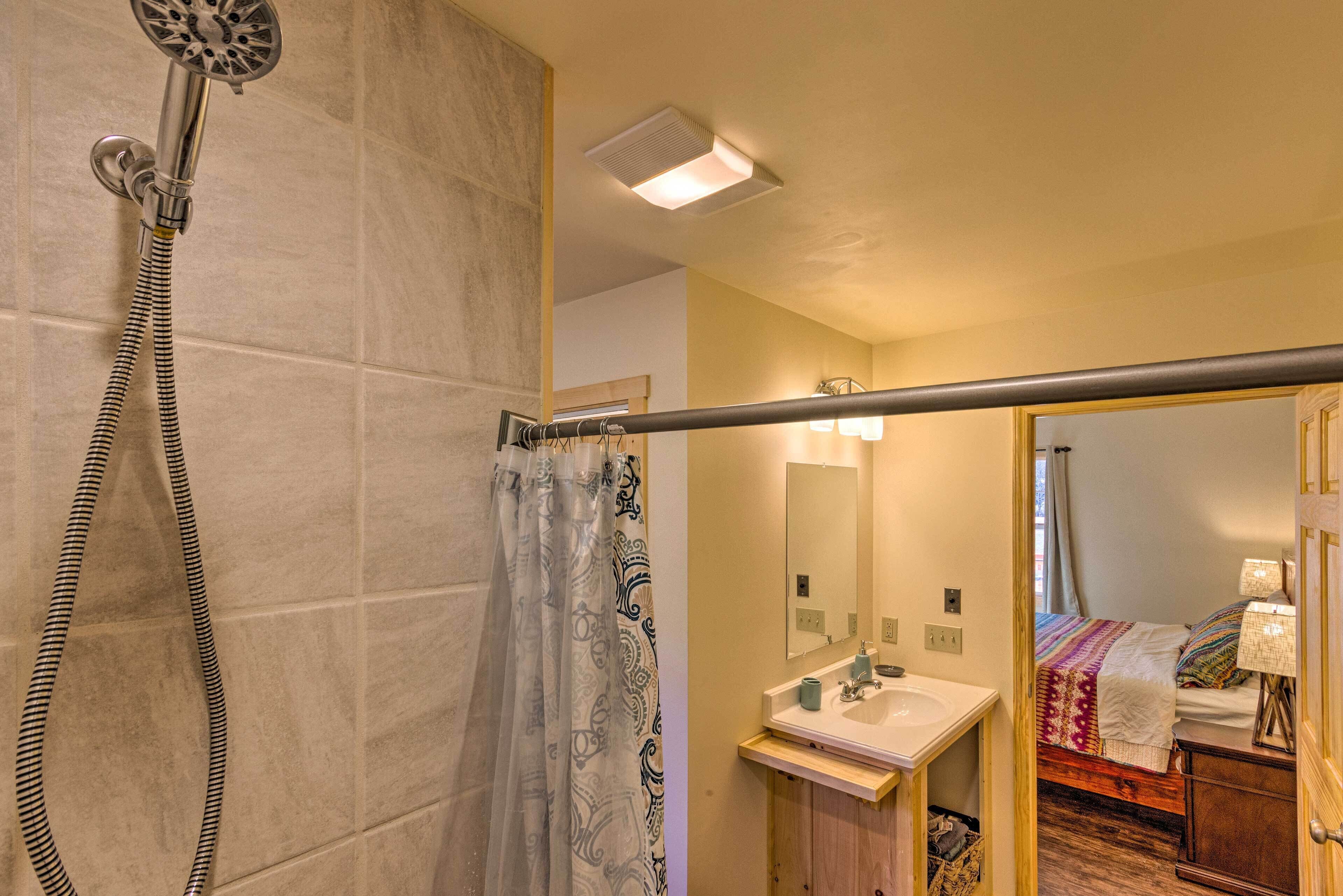 A bathroom with a shower, a sink, and a mirror.