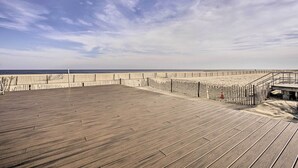 A wooden deck with a view of the beach and ocean. - Jersey Shore Getaway w/ Grill: Walk to Beach! (Belmar)