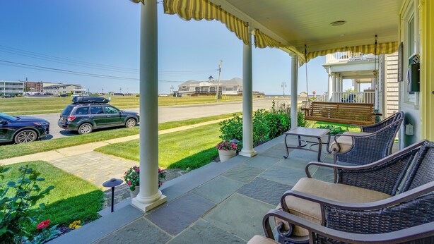 A covered porch with wicker furniture, a bench, and potted plants. - Jersey Shore Getaway w/ Grill: Walk to Beach! (Belmar)