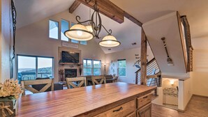 A spacious kitchen with a large wooden island, a dining area with a view, and a staircase leading to an upper level.