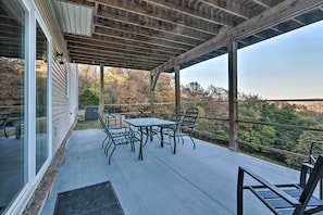 A covered patio with a table and chairs, a wooden pergola, and a view of trees. - Pet-friendly Branson West Lodge w/ Hot Tub! (Branson West)